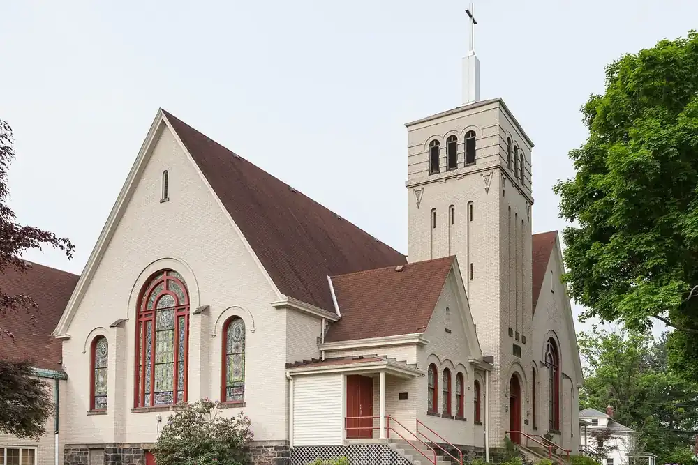 Light-colored Bethel Presbyterian Church with a stained glass window and bell tower in Bethel Park, Pennsylvania